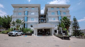 A symmetrical, multi-story building with a central entrance and a white facade. - Kigali Delight Hotel (Kigali)
