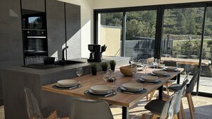 A modern kitchen with a large island, dining table, and chairs. - VILLA with private pool, near MONT VENTOUX and VAISON LA ROMAINE (Mollans-sur-Ouvèze)