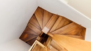 Eine hölzerne Wendeltreppe mit einer Zwischenplattform.