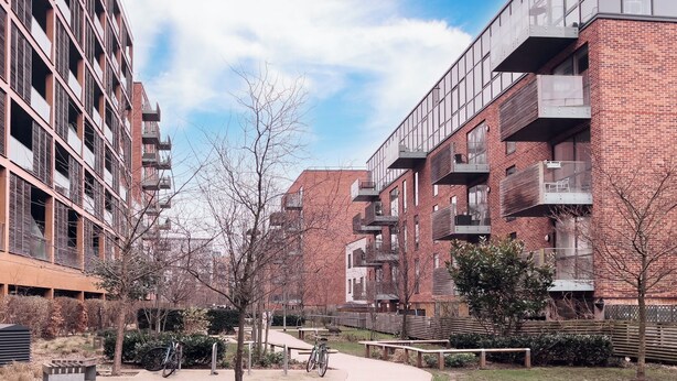 A modern apartment building with multiple balconies and a pedestrian pathway. - Cozy 2 Bedrooms, Devons Road DLR (London)