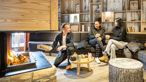 A cozy living room with a fireplace, wooden shelves, and a coffee table. - Apartment in France With Ski-in/ski-out Access (Risoul)