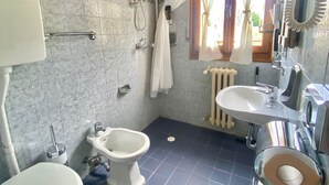 A bathroom with a toilet, bidet, and shower area. - Rifugio Calvanella (Sestola)