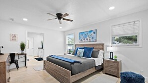 A bedroom with a bed, bedside table, nightstand, and a ceiling fan. - The Jupiter Hideaway (Jupiter)