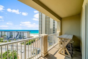 Un balcon avec vue sur la plage et les immeubles de grande hauteur.