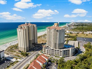Un hôtel de grande hauteur, avec de nombreux étages, un parking et une vue sur la plage.
