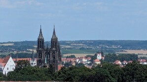 A historic church with twin spires, surrounded by residential buildings and greenery.