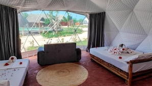 A tent-style room with a bed, a sofa, and a dining table. - Paradise city (Kidoti)