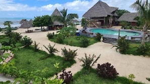 A resort with thatched-roof buildings, a swimming pool, and a beach. - Paradise city (Kidoti)