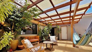 A covered patio with wooden furniture, a hammock, and various potted plants. - Seascape - Kalbarri, WA (Kalbarri)