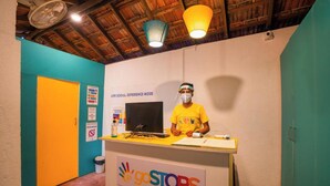 Un comptoir d’accueil avec une pancarte « goSTOPS », un ordinateur et une personne portant un t-shirt jaune.