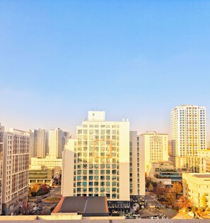 A high-rise building with multiple floors, surrounded by other tall buildings, and a clear sky.
