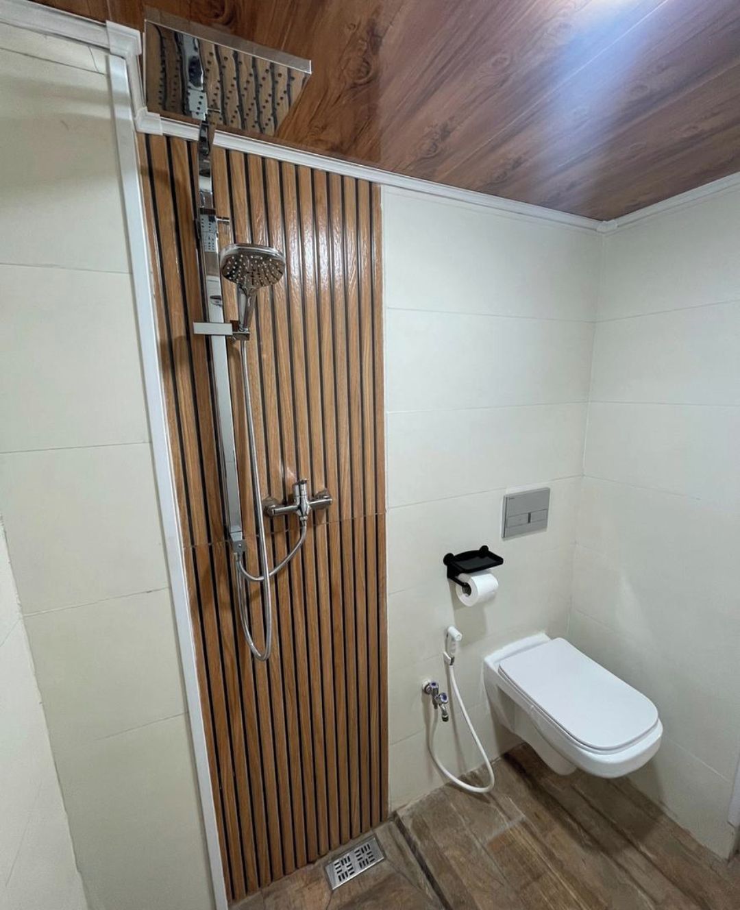 Une salle de bain avec douche, toilettes et lavabo.