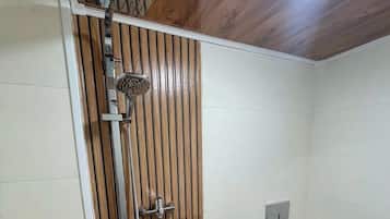 Une salle de bain avec douche, toilettes et lavabo.