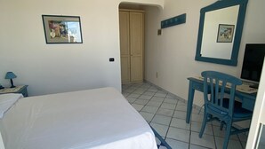 Una camera da letto con un letto, una scrivania, una sedia e una porta.