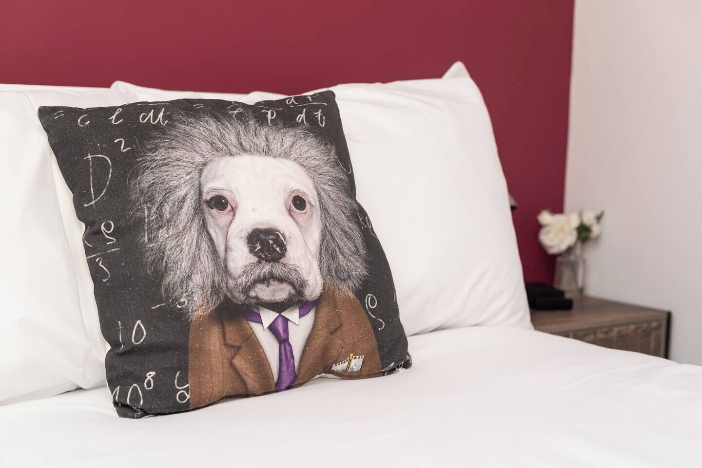 Un cojín con una ilustración de un perro sobre una cama.