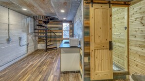 A compact kitchen with a wooden staircase, a sink, and a window. - Stunning, Spacious Mountain Home near Deadwood & 4X4 Trails (Lead)