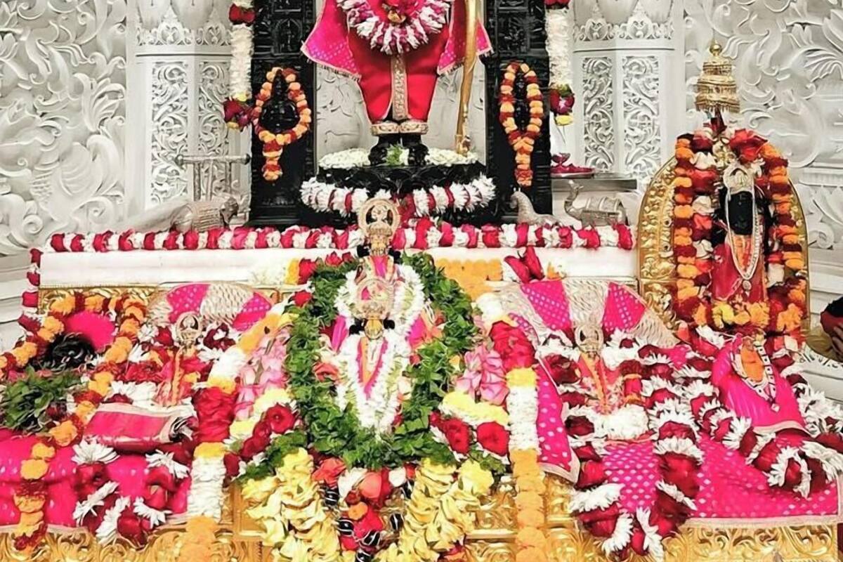 A temple with intricate carvings and a central deity figure adorned with garlands.