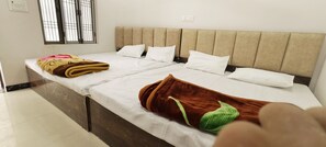 A double bed with a beige headboard, white pillows, and a brown blanket. - SHRI AYODHYA DHAM HOTEL AND RESTAURANT (Faizabad)