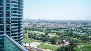 A high-rise building overlooking a golf course with a city skyline in the distance. - Zapbed House - LW 2007 (Dubai)