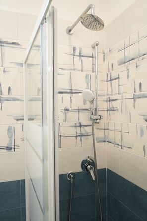 Familiekamer, uitzicht op de stad | Badkamer | Een douche, een haardroger, handdoeken, zeep