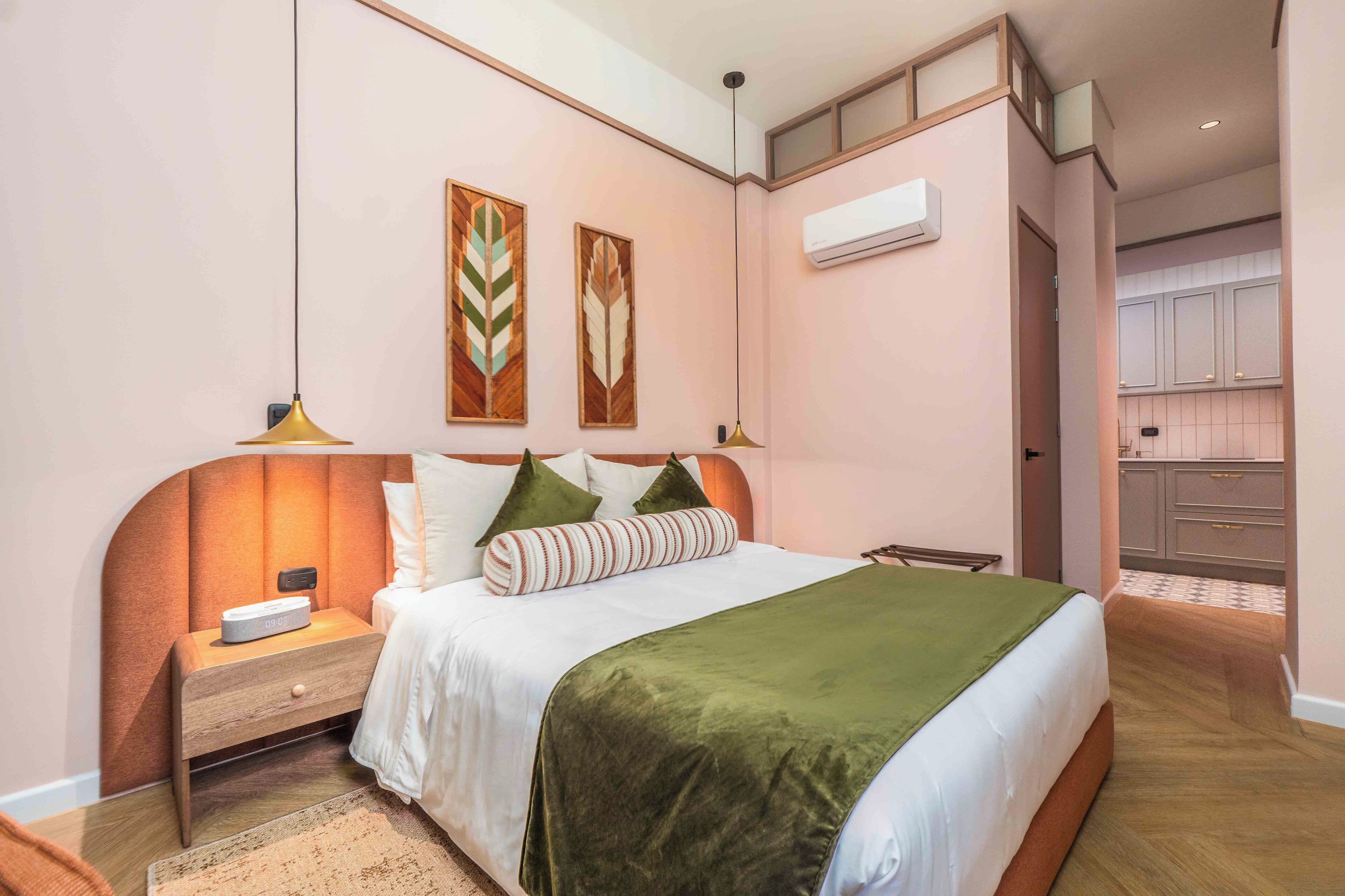 A bedroom with a bed, nightstand, and wall-mounted air conditioner.