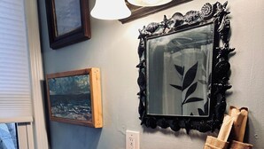 A bathroom with a white sink, a mirror with an ornate frame, and a shelf with a bag and a bottle. - Walkable near downtown 1 Bedroom (Portland)