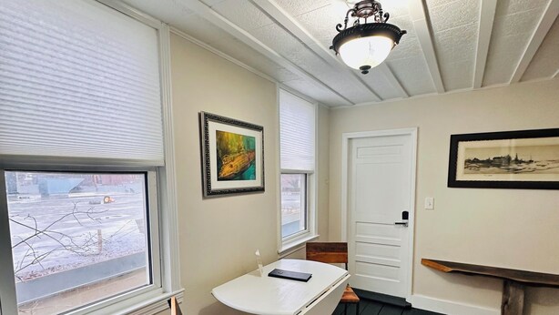 A room with a white table, a chair, a colorful rug, and a ceiling fan. - Walkable near downtown 1 Bedroom (Portland)