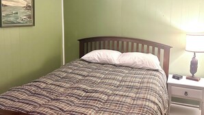 A bedroom with a bed, a nightstand, a lamp, and a painting on the wall. - Walkable near downtown 1 Bedroom (Portland)