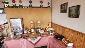 A breakfast buffet setup with various food items and a coffee station. - Pousada Cachyto de Cielo (Campos do Jordão)