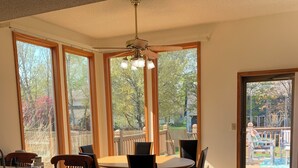 A spacious kitchen with a dining area, large windows, and a view of the backyard. - Peaceful 3-bedroom accessible ranch home with AC, WiFi in Eastside Olathe. (Olathe)