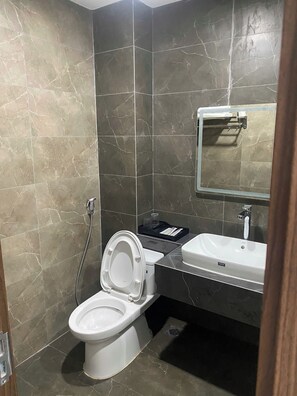 Un baño moderno con inodoro, lavabo y ducha.