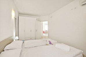 A hotel room with a bed, a wardrobe, a desk, and a chair.