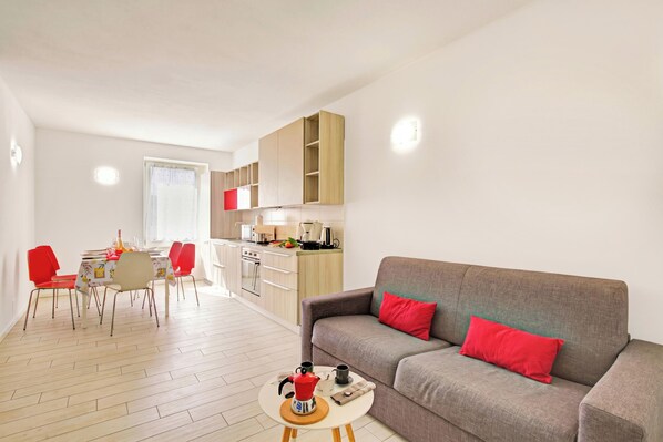 A modern apartment with a dining area, kitchen, and living room.
