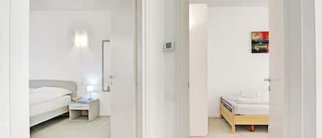A modern bedroom with a bed, bedside table, and a nightstand.