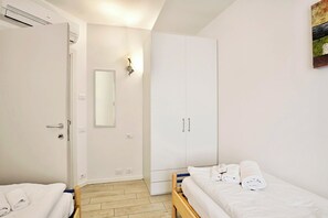 Een slaapkamer met een bed, een kledingkast, een spiegel en een deur.