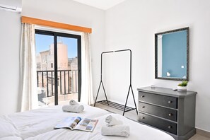 Ein Hotelzimmer mit einem Bett, einem Schminktisch, einem Spiegel und einem Fenster mit Vorhängen.