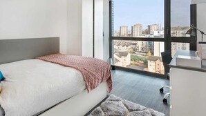 A modern bedroom with a large window, a bed, a desk, and a chair. - Chapter Lewisham Student Only Cozy Stay (London)