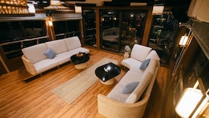 Un área de estar moderna con dos sofás, una mesita de centro y un sillón de mimbre.