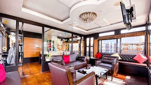 Un salón moderno con sofás de cuero, una mesa de centro y un amplio ventanal con vistas a la ciudad.
