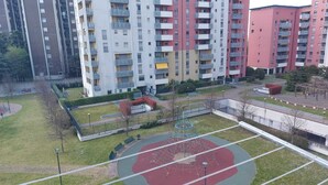 Zona residencial con edificios de apartamentos de varios pisos, un parque infantil y una cancha deportiva.