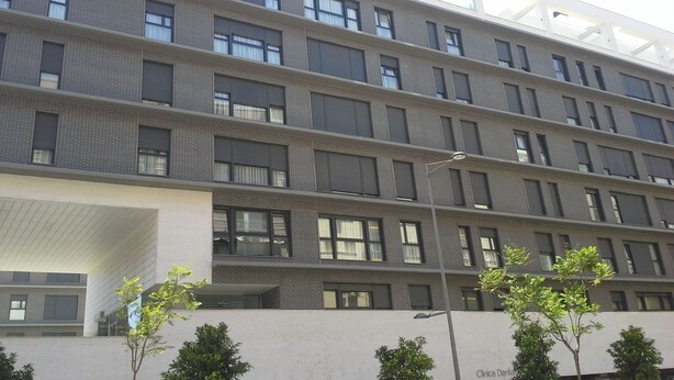 Un immeuble à plusieurs étages doté d’une architecture moderne, caractérisé par une série de balcons et de grandes fenêtres.