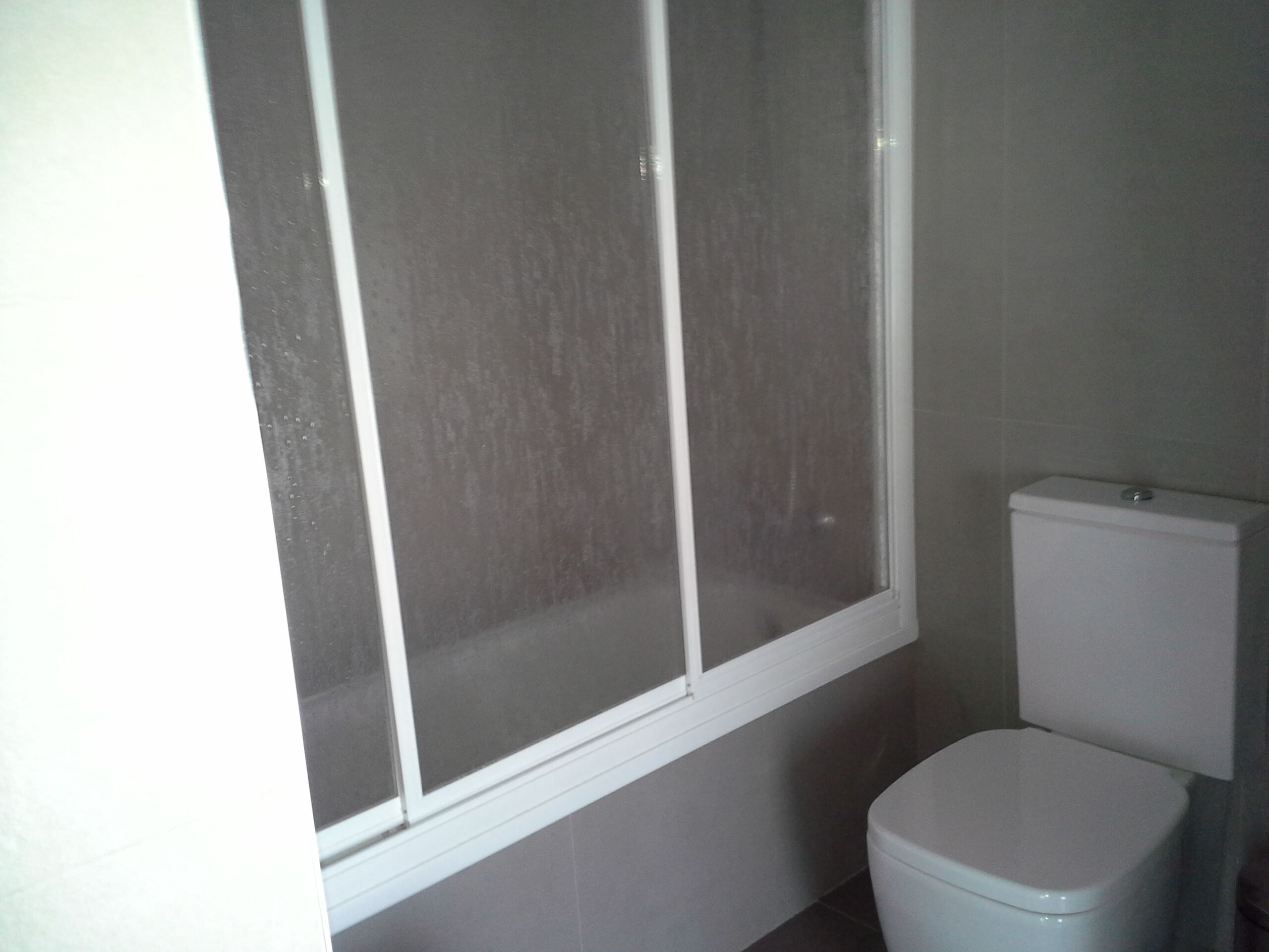 Un baño con inodoro y ventana.