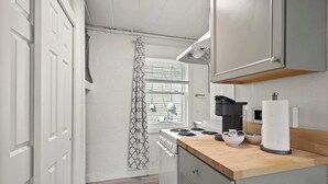 A modern kitchen with a stove, oven, and wooden countertop. - Chic City Retreat 93F (Columbus)