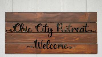 A wooden sign with the text "Chic City Retreat Welcome".