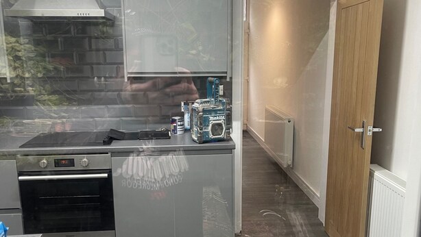 A modern kitchen with a built-in oven, a stainless steel range hood, and a wooden door. - Shawforth - 2 Beds - Sleeps 4 - Street Parking (Rochdale)