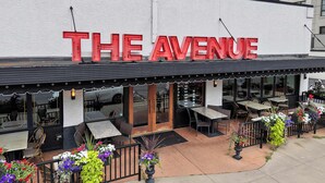 Een restaurant genaamd "The Avenue" met terras en een witte gevel.
