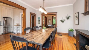 Un comedor amplio con una mesa y sillas de madera, una cocina moderna con electrodomésticos de acero inoxidable y una acogedora chimenea.