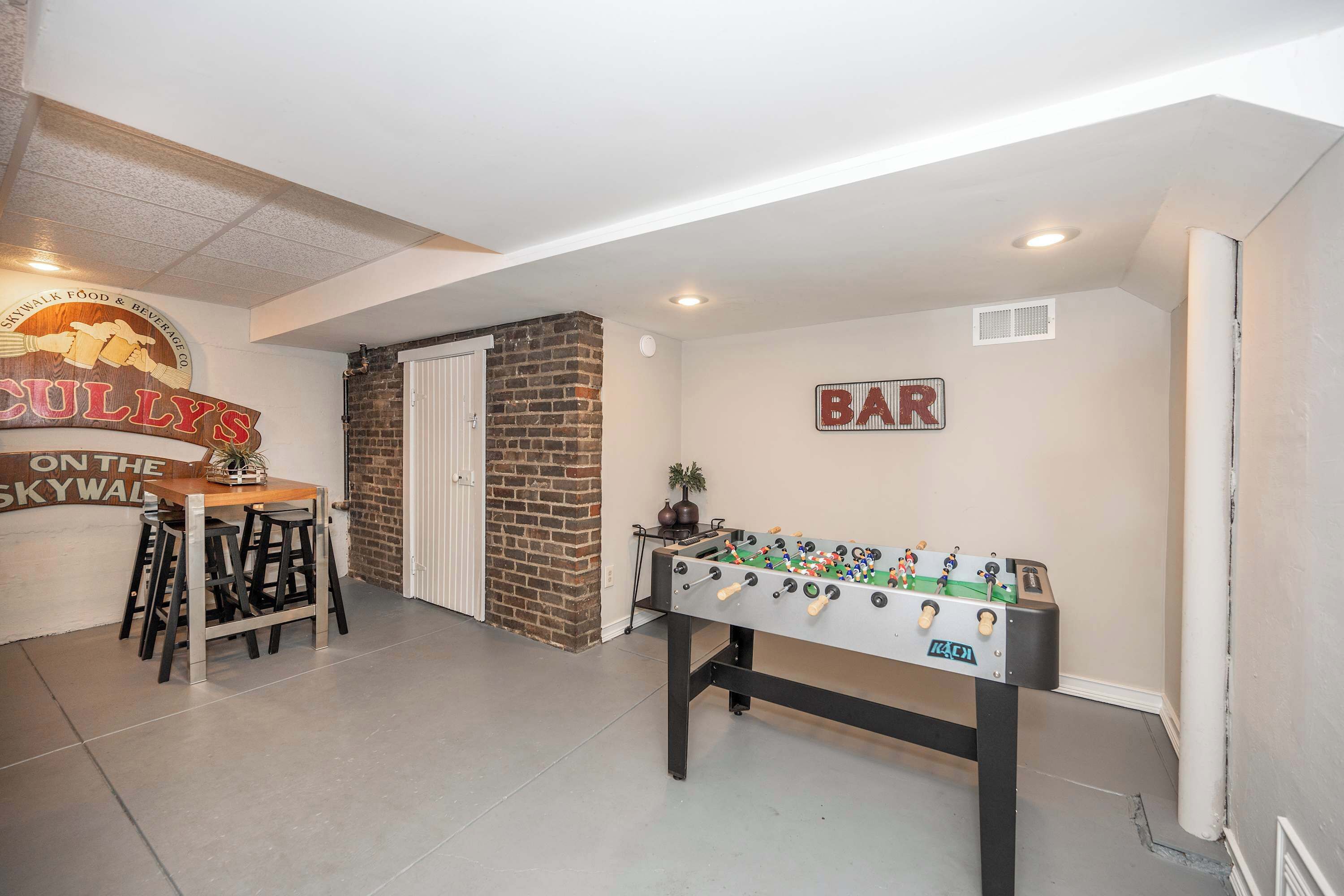 A room with a foosball table, a bar sign, and a sign for 'BULLY'S ON THE SKYWALK FOOD & BEVERAGE CO.'