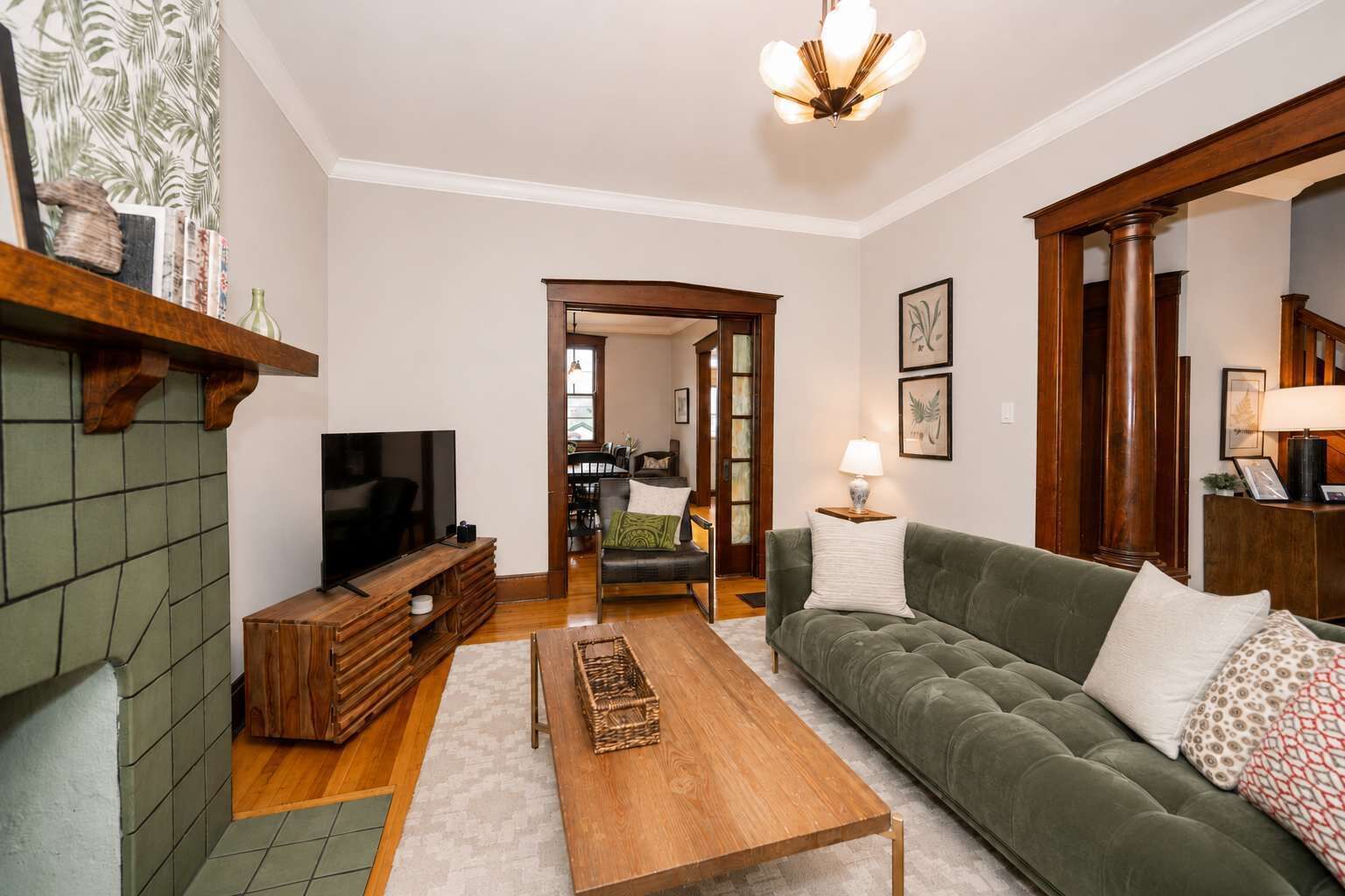 A living room with a television, sofa, coffee table, and fireplace.
