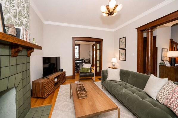 A living room with a television, sofa, coffee table, and fireplace.